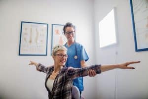 a woman holding her arms out while receiving a physical exam