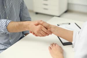 Picture of a primary care doctor shaking hands with a patient.