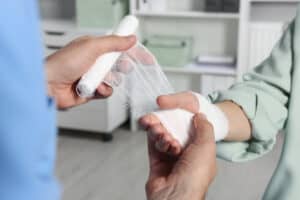 Picture of a doctor applying gauze to the hand of a patient with a minor burn.