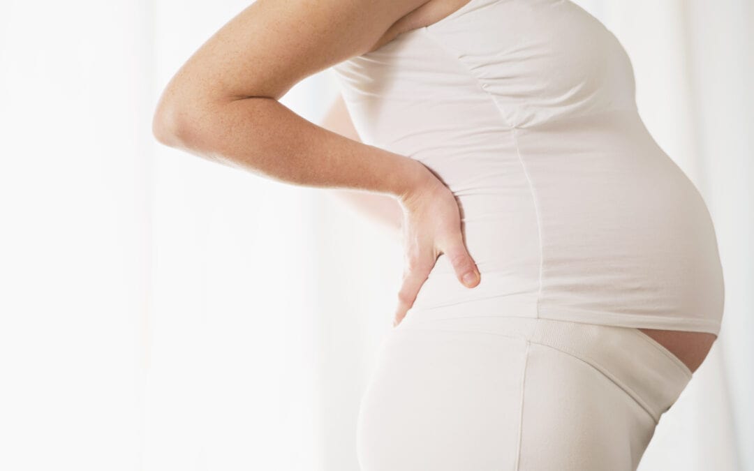 Picture of a pregnant women standing with her hands on her hips.